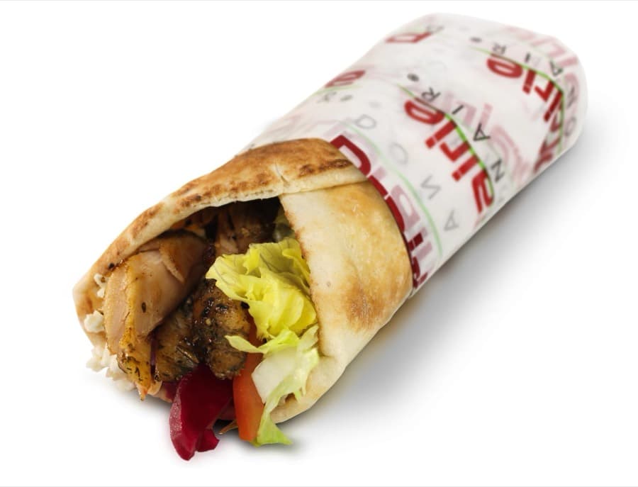 A donair wrapped in warm flatbread and branded paper, packed with carved meat, lettuce and tomato.
